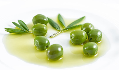 Plate with olives, olive oil, twig, olive branch