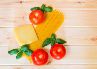 Spaghetti pasta with fresh tomatoes and parmesan cheese on wooden background