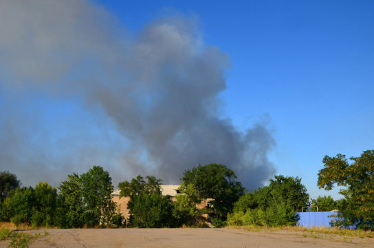 
Clubs of smoke are visible because of a two-story house.