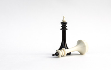 Chess pieces. Victory of black over the white king on white background