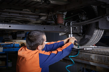 Mechanic Works on a Car in body shop