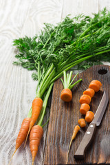 Carrot and knife on wooden board.  Selective focus, close up, space for text.