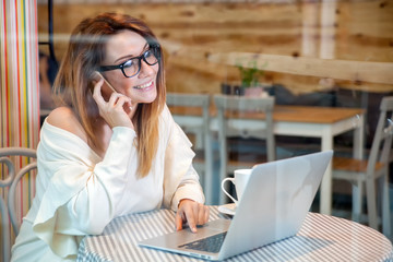 Business woman working with laptop and mobile phone at cafe, freelance concept