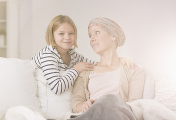 Small girl comforting ill mother