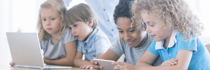 Children using laptop and smarthopne