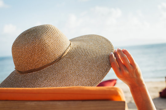 Close Up of Woman With Large Straw Hat Tanning on Sunbed