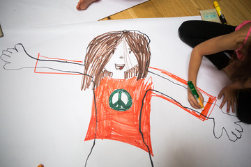 Girl sitting colouring in body trace outline