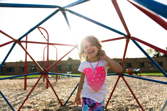 Girl on monkey bars in playground