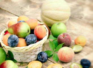 Fresh organic seasonal fruits in wicker basket on table