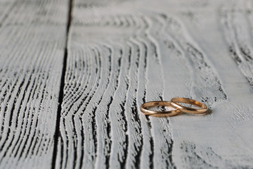 Wedding rings on white wooden background. Space for text