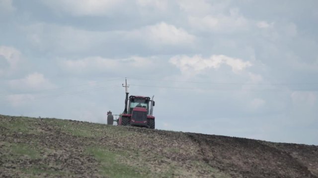 Agriculture machine spread fertilizer on cultivated field soil in summer. Planting crops. blue sky