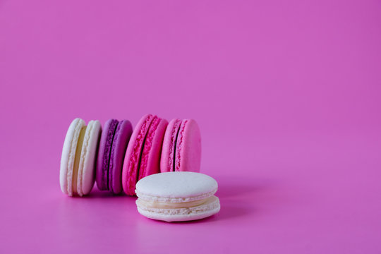 Tasty french macaroons on pink background