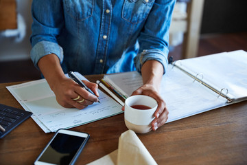 Businesswoman writing on check in her office