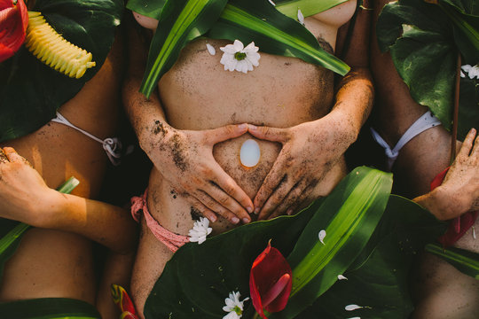 Beautiful naked female body covered with tropical flowers and plant