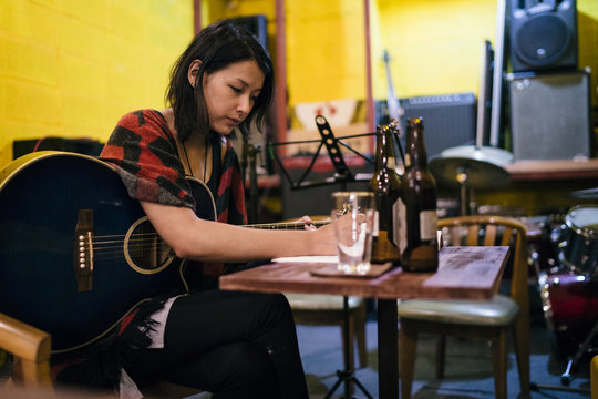 Asian Woman Playing The Guitar