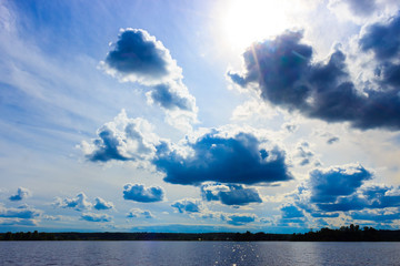 big massive clouds in the blue sky at a russian lake