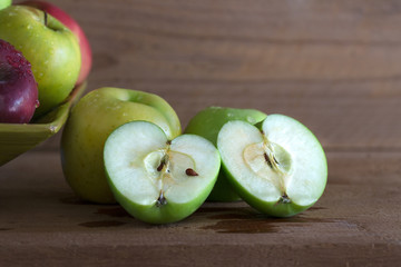 Pile of fresh apples in the green wooden tray on wooden table