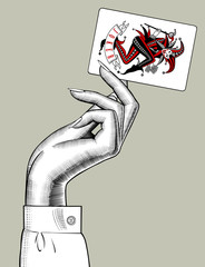 Hand of woman holding Joker playing card