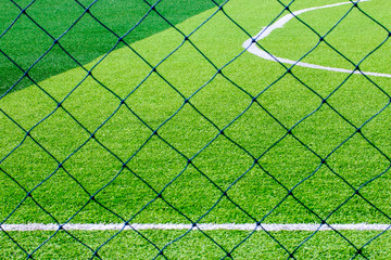 Photo of a green synthetic grass sports field with white line shot from above