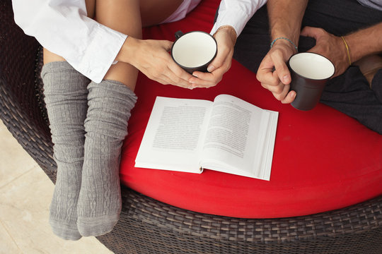 Love couple drinking tea and reading book. Family morning together