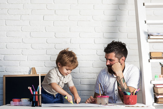Crayons drawing family, father looks how son draws. Development of motor skills and thinking in children garden, teacher and pedagogy, art therapy.  Small artist paints with felt-tip pens and fingers