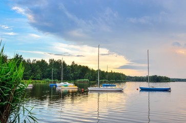 Fototapeta na wymiar Boats on a beautiful lake. Evening summer landscape by the water.