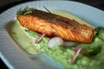 Baked trout with sauce and broccoli