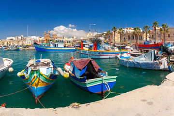 Naklejka premium Traditional eyed colorful boats Luzzu in the Harbor of Mediterranean fishing village Marsaxlokk, Malta