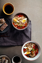Lunch with udon noodles cooked with vegetables. Top view. Composition with copy space on concrete background