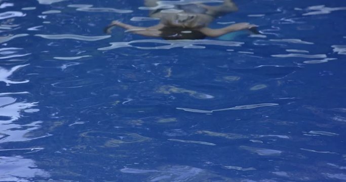 Sexy Young Woman Holding the Back of her Neck with Two Hands While Emerging herself at the Swimming Pool and Smiling. Slow motiom 4k