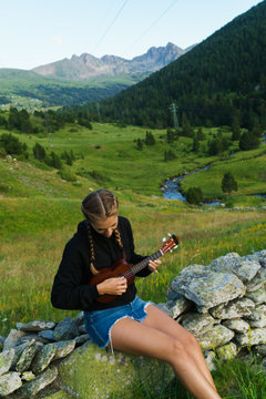 Woman playing ukulele in nature