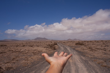 Female hand indicating destination on a empty road