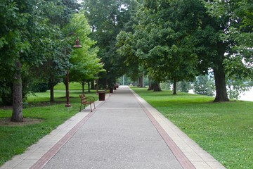 Fototapeta na wymiar The long walkway in the park under the shade trees.