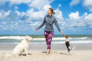 Woman training dogs on the beach