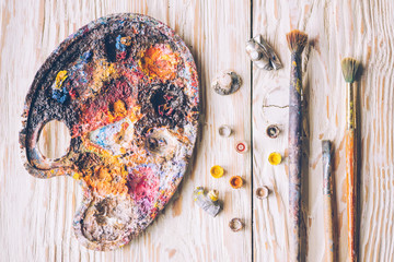 Oil paints and paint brushes on a palette closeup.
