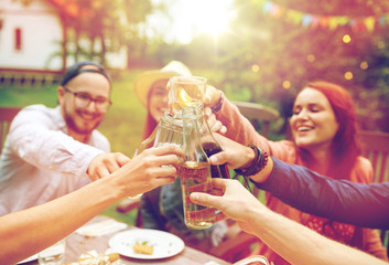 happy friends with drinks at summer garden party