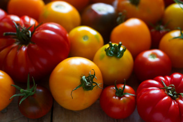 Tomato of different varieties on a wooden background