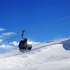 Fototapeta na wymiar Gondola lift on ski resort at sun wind day