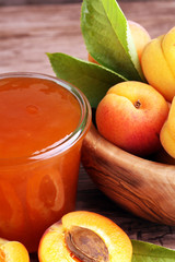 Apricot jam in glass bowl with fruit around
