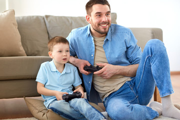 father and son playing video game at home