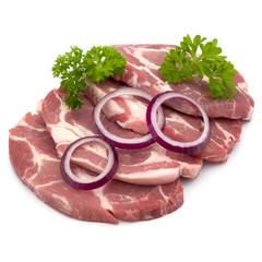 Raw pork neck chop meat with parsley herb leaves and onion slices garnish isolated on white background cutout