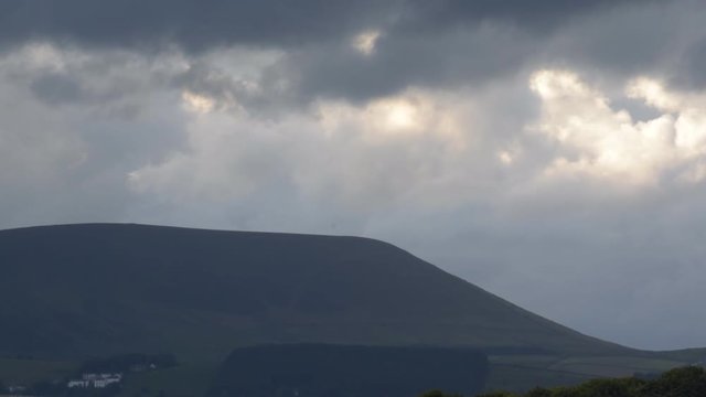 Moving clouds over Pendle Hill, summer evening dark cloudy sky in Forest of Bowland, Lancashire, England UK