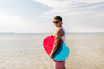 Naklejka na ściany i meble happy young man with skimboard on summer beach