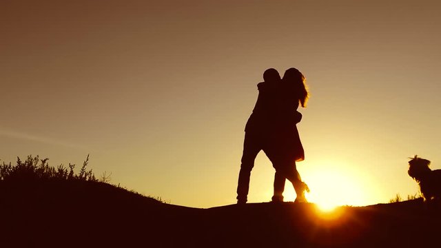 man spinning his girl in a circle. Couple dancing at sunset . Man and Woman love silhouette in sunset slow motion video. Couple family in love kissing at sunrise silhouette
