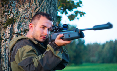 Hunter aiming a gun at wild animals