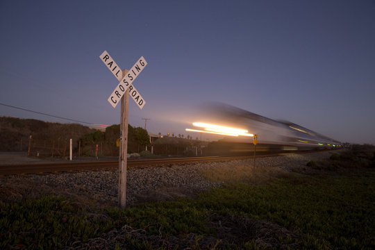 Railroad crossing sign and passing train in California