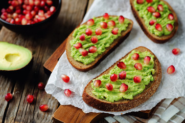 Smashed avocado pomegranate rye sandwiches