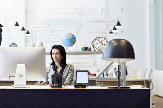 Businesswoman working on desktop computer in creative office