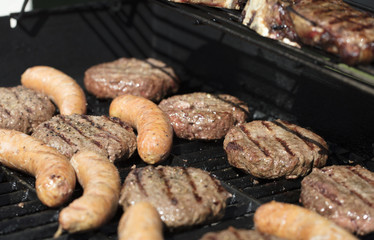 Hamburger, sausage and steak barbecued on the grill