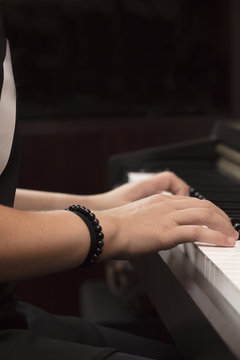 Young person playing the piano with both hands
